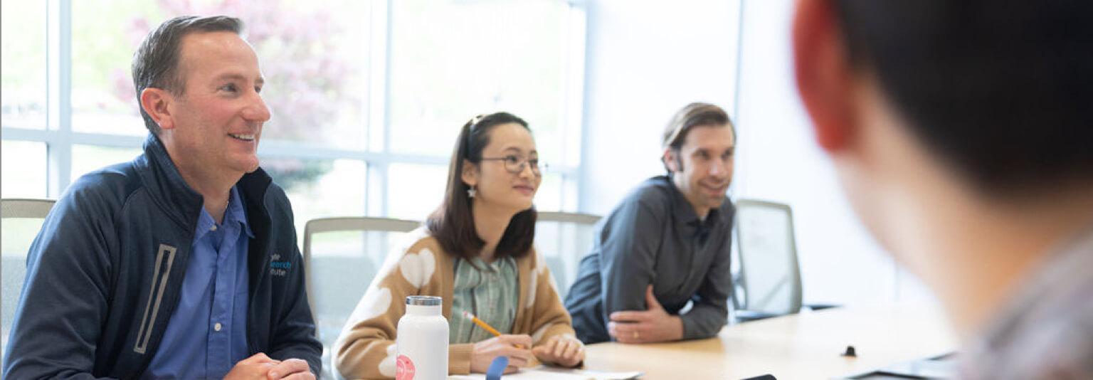 Group of people sitting around a conference table and talking